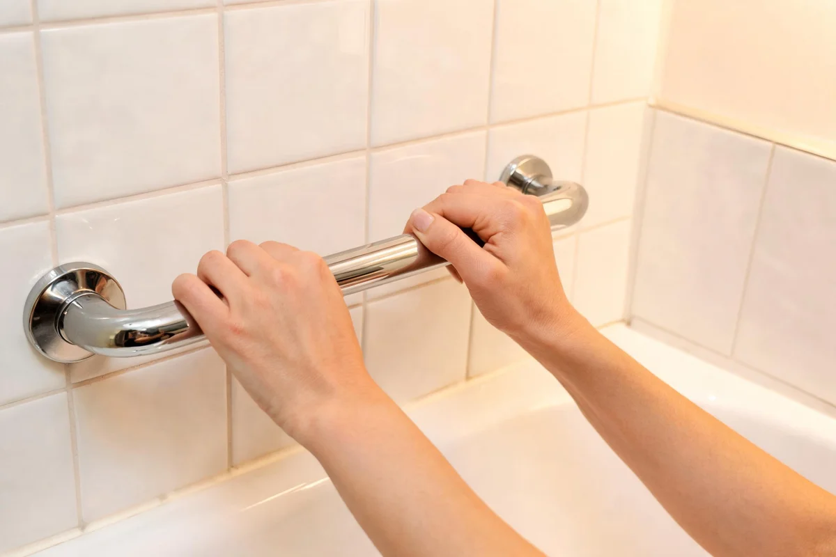 Senior in a bathroom with safety grab bars installed